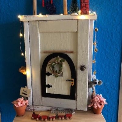 Weihnachtlich geschmückte Modell-Haustür mit Lichterkette