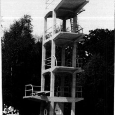 schwarz-weiß Fotografie des Freibades; Sprungturm, Person ist im Begriff zu springen
