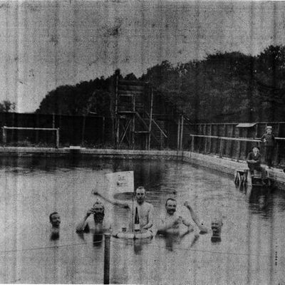 schwarz-weiß Fotografie des Freibades; Männer mit Flaschen im Wasser