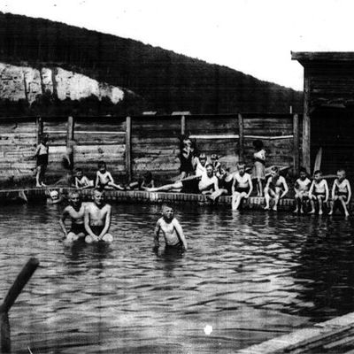 schwarz-weiß Fotografie des Freibades; Gruppe Kinder im und am Wasser